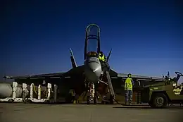 Front view of F/A-18F Super Hornet on tarmac with several ground crew