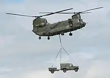 A vehicle being carried underneath a helicopter