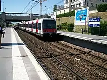 Train MI 84 arriving at the station (towards Marne-la-Vallée–Chessy)  and sign indicating the name of the station