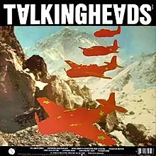 Album cover containing a drawing of a mountain range and four mostly red warplanes flying in formation. There is green text on the left hand side and a barcode in the top right corner.