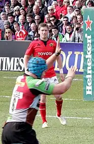 Ronan O'Gara standing in the field  with Munster, near a Heineken-sponsored post pad, in 2013