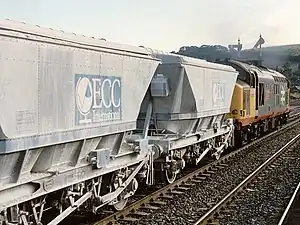 Silvery-white railway wagons being hauled by a Diesel locomotive