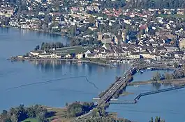 Rapperswil as seen from Etzel mountain: Capuchin monastery to the left, Rapperswil castle and St. John's church in the background, Lake Zürich harbour and Altstadt in the foreground respectively Seedamm, wooden bridge and upper Lake Zürich to the right (October 2010)