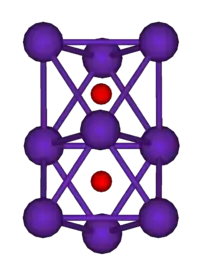 The ball-and-stick diagram shows two regular octahedra which are connected to each other by one face. All nine vertices of the structure are purple spheres representing rubidium, and at the centre of each octahedron is a small red sphere representing oxygen.