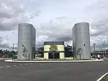 Green building with two large metal towers on either side