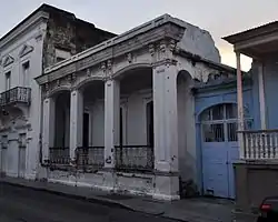 Photograph of the Zaldo de Nebot Residence, a one story building with a prominent cornice and pillared front in an urban setting