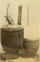 South Sudan or Northern Uganda. Acholi people, trough zither (center back), arched harp (left), unnamed flute (right). Circa 1880. The zither is a nanga or possibly  kinanda.