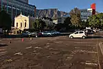 Riebeeck Square – one of the squares round which Cape Town developed. It was first known as Boeren-plein, and later as Hottentot Square. Here the farmers
outspanned their wagons and off-loaded their products. During the seventeenth century Cape Town expanded for the most part from the sea towards Table Mountain along the axis of the Heerengracht or Adderley Street. During the eighteenth century it expanded laterally also, and began to fill Table Valley. Type of site: Square.