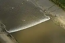 A tidal bore wave moves along the River Ribble between the entrance to the river Douglas and Preston.