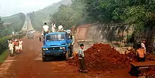 Roadwork construction in North Korea. The blue truck in the foreground is a Chinese-made Dongfeng.