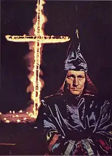 A klansman before a burning cross