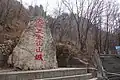 A rock inscribed with the name of Wunü Mountain City, and the UNESCO logo