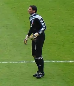 A man wearing a black football kit before a game.