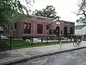 Roosevelt Library, a small Tudor Revival building surrounded by a neat lawn and black fence