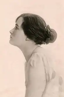 A young woman in profile, with dark hair in a bun.