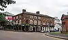 A brick public house in three storeys with some rendering on the ground floor