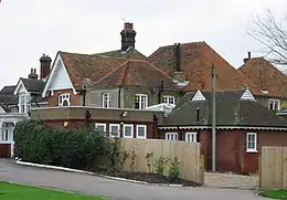 Building of a Georgian style, partly obscured by low-level buildings in front