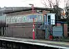 A brick signal box with a flat concrete roof, and a row of steel-framed windows