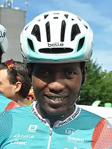 closeup of man wearing a racing helmet and smiling broadly