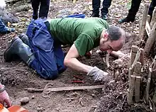 Colour photograph of Martin Rundkvist excavating a 16th-century sword