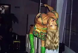 Spears Leaning backwards from a revolving pole with her "I'm a Slave 4 U" outfit