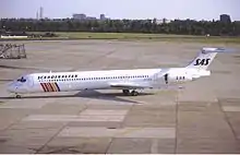 A medium jetliner with an all-white body and colored stripes