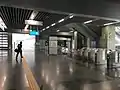 Unpaid area and fare gates at the concourse level of the station.