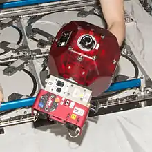 A SPHERES satellite equipped with add-on VERTIGO goggles.