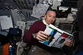 Mission Specialist Randolph Bresnik reading his crew notebook on the aft flight deck