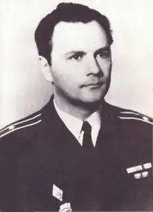 A man in a naval uniform stares off to the left of the camera