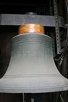 An image of a grey bell, located in the bell tower of Saint Anthony's Church in Prague, Czech Republic.