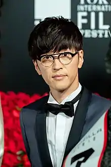 A bespectacled, formally-dressed Takahiro Sakurai at the 2018 Tokyo International Film Festival