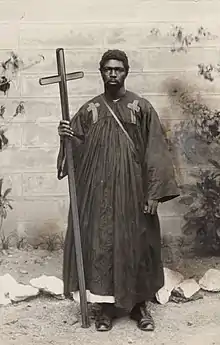 Oppong in his robes, holding his wooden cross