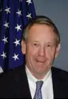 man in business suit, American flag in background