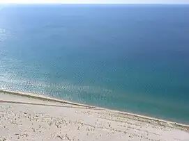 Lake view from the Sleeping Bear Dunes National Lakeshore, with people climbing uphill