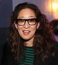 Sandra Oh smiling at the camera wearing sunglasses