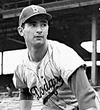 "A young baseball player wearing a ballcap with the initial 'B'."