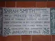 A tablet formed of six standard sized tiles, bordered by green flowers in the style of the Arts and Crafts movement