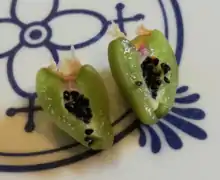 Green fruit of Schlumbergera cut in half, lying on a cutting board.