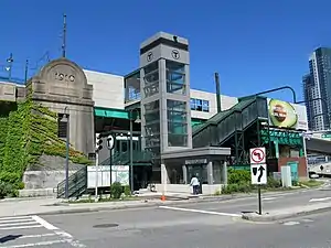 An elevated light rail station in an urban area seen from below