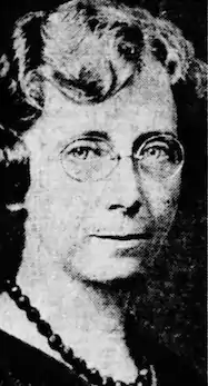 A middle-aged white woman with light hair and glasses