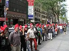 Customers wearing rooster hats while waiting in line for the start of Scribblenauts launch event.