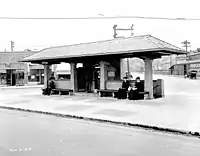 A transport station with benches under a roof in the middle of a city square inset with inconspicuous rectangles of vault lights