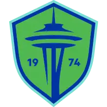 The Seattle Sounders FC crest, a green and blue shield with the shape of the Space Needle in the center and the year of the club's founding (1974).