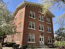 Three-story red brick building with arched windows