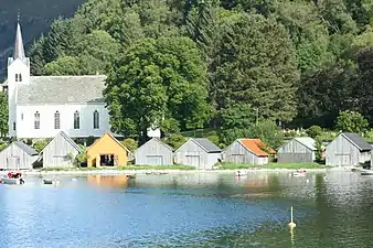 View of the church with small boat houses along the shore