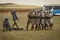 Malaysian UN peacekeepers protected by Mongolian soldiers while treating a simulated casualty in a riot control exercise during Khaan Quest 2016