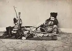 1864 photo of Californian Seth Kinman displaying an Indian scalp (front left). He collected "Indian artifacts" including scalps.