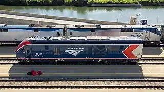 A blue diesel locomotive with red and silver chevrons at the rear