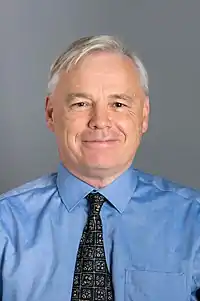 Man with grey hair wearing blue shirt